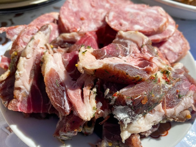 Um prato com deliciosa carne vermelha defumada, presunto, bacon, banha, linguiça e pescoço de porco
