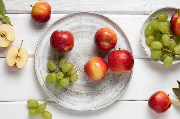 Um prato com frutas frescas, como maçãs e uvas