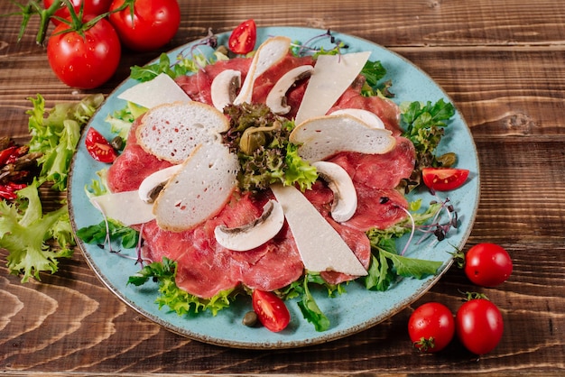 Um prato com peixe vermelho, queijo e cogumelos em fundo de madeira