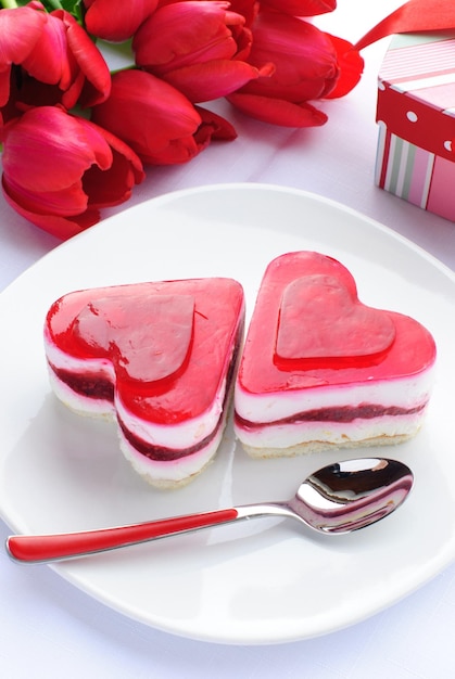 Foto um prato com um bolo em forma de coração e uma colher nele