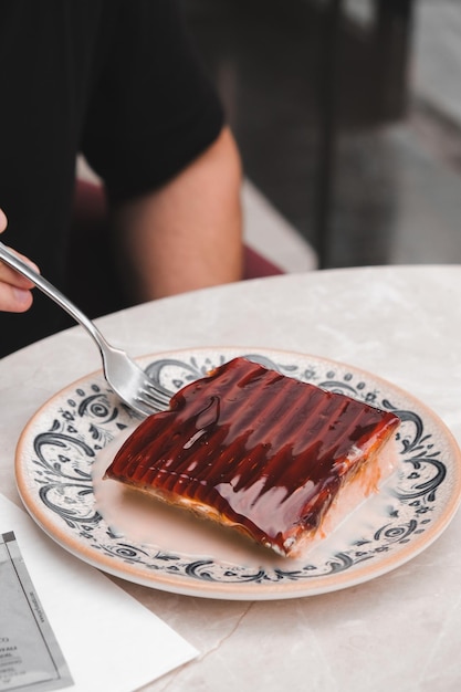 um prato com um pedaço de bolo coberto de chocolate