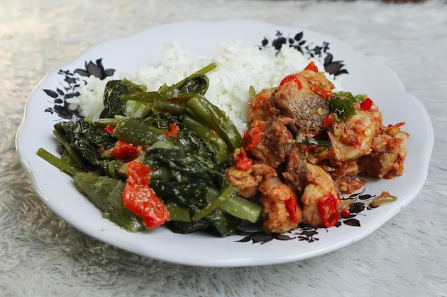 Foto um prato de arroz com um prato de sampel de stingray e lodeh de vegetais típico do lombok indonésio