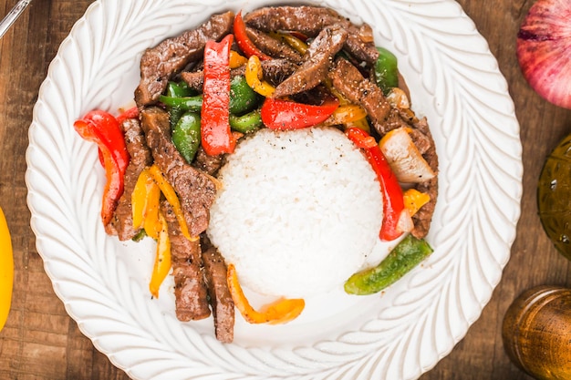 Um prato de arroz de carne frita com pimenta verde