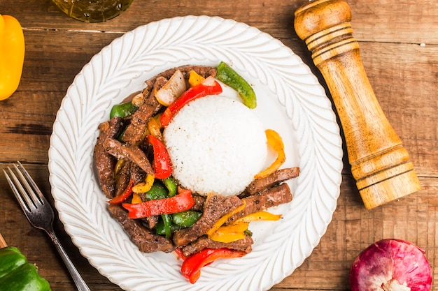 Um prato de arroz de carne frita com pimenta verde