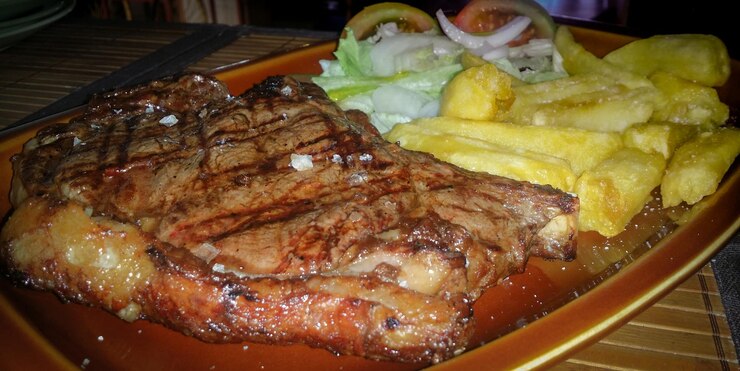 Foto um prato de bife e batatas fritas com salada