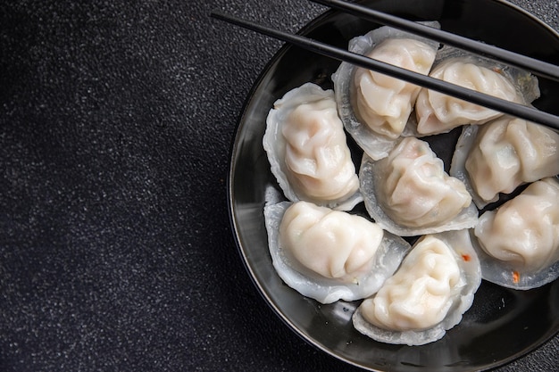 Um prato de bolinhos com pauzinhos nele