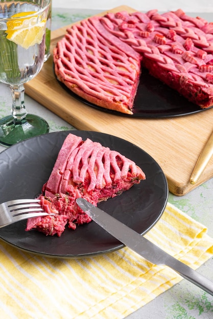 Um prato de carne com um garfo e uma taça de vinho ao lado.