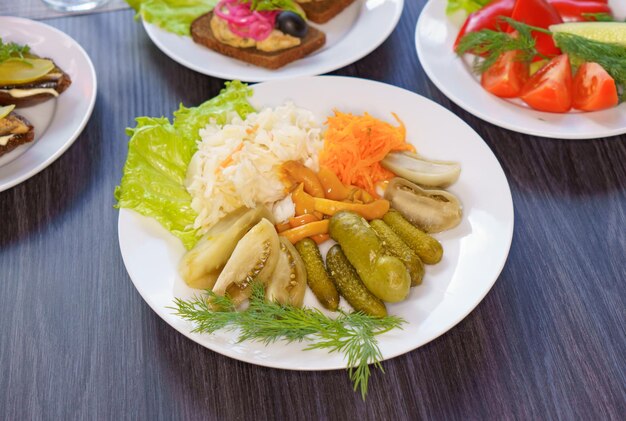 Um prato de comida com picles e outros vegetais
