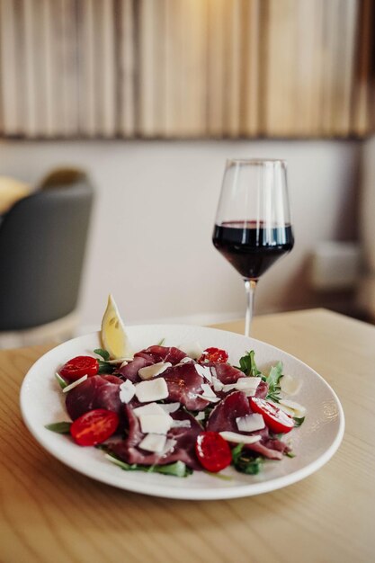 Um prato de comida com um copo de vinho na mesa