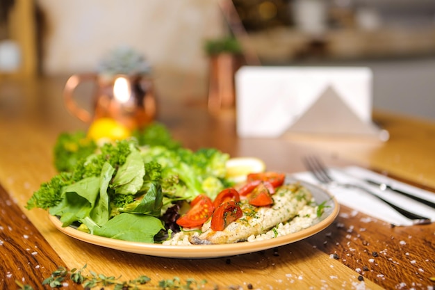 Um prato de comida com um garfo e uma tigela de salada