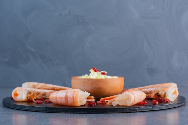 Um prato de madeira com deliciosos camarões em uma superfície de pedra