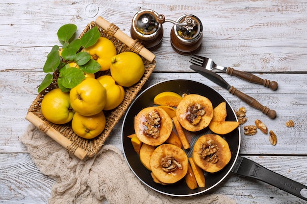 Um prato de marmelo em uma frigideira com especiarias em uma mesa de madeira clara