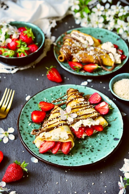 Um prato de morangos e crepes de creme com chocolate salpicado por cima.