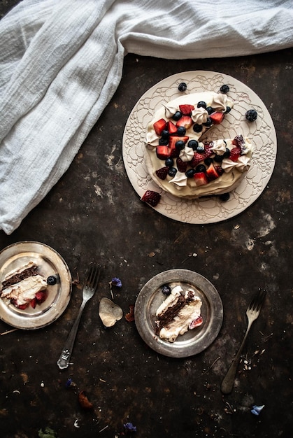 Um prato de pavlova com uma fatia de bolo por cima