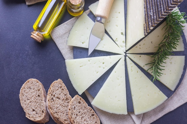 Um prato de queijo Manchego curado com uma faca e azeite virgem