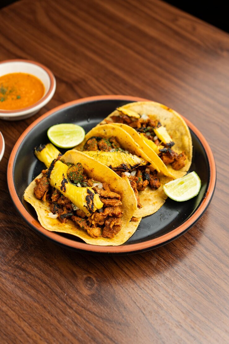 Foto um prato de tacos e um prato de comida com uma colher nele.