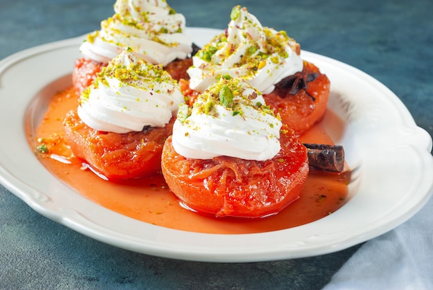 Um prato de tomates vermelhos com chantilly e pistache