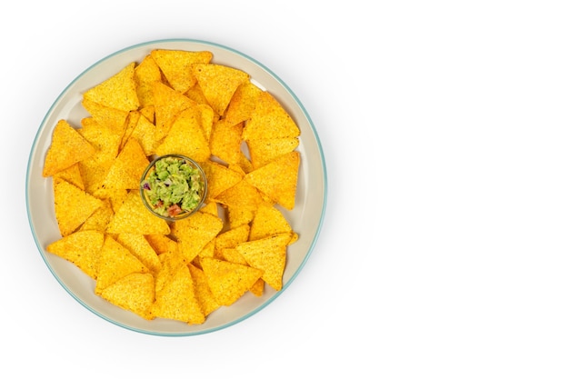 Um prato grande com nachos crocantes e chips de guacamole no centro do prato em um prato branco