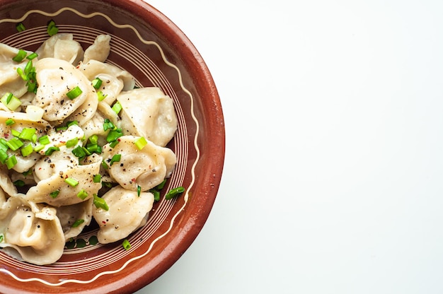 um prato tradicional clássico de bolinhos de pelmeni com carne, manteiga, pimenta e verduras, comida