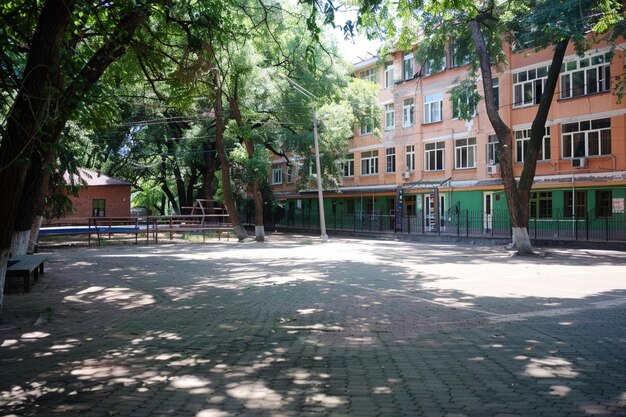 Foto um prédio escolar com um pátio ensolarado para sessões de estudo ao ar livre
