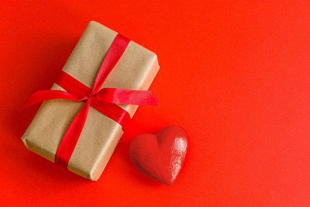 Um presente e um coração em um fundo vermelho Dia dos Namorados
