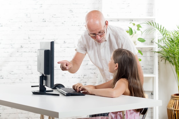 Um professor ajuda uma estudante em um computador