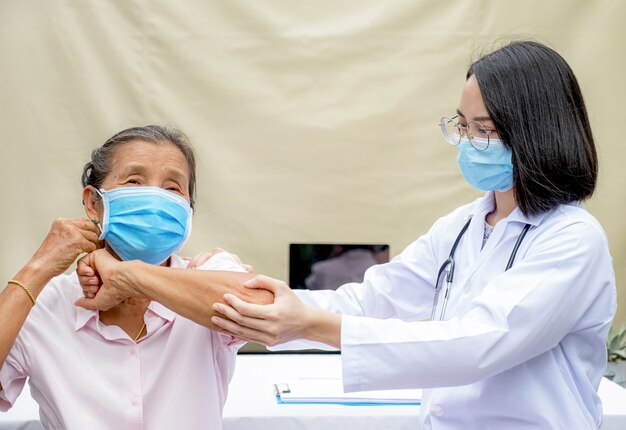 Um profissional de fisioterapia médico está fazendo terapia das mãos em pacientes idosos no hospital.