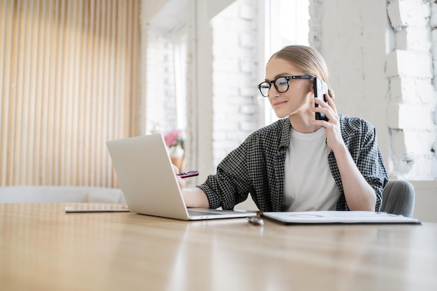 Um programador feminino trabalha usa um laptop faz um relatório para uma empresa de programação