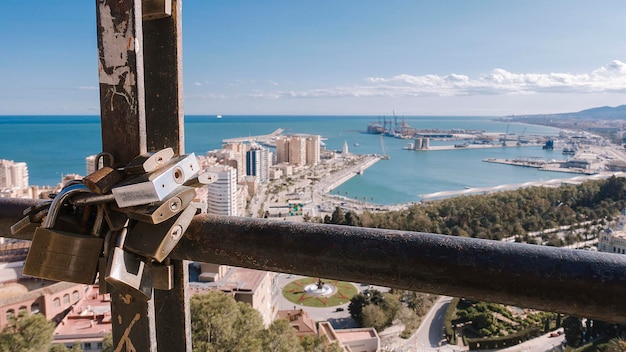 Um punhado de cadeados presos ao mirante elevado de Málaga, onde você pode vislumbrar a costa