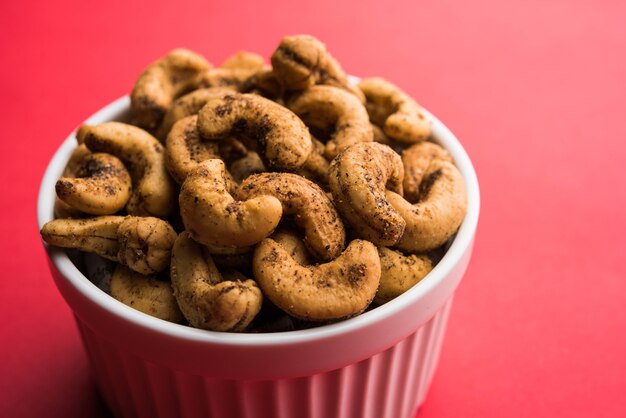 Um punhado de castanhas de caju torradas com especiarias ou masala kaju servido em uma tigela, com foco seletivo