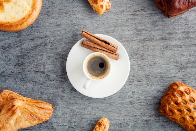 Um quadro de bolos e croissants em torno de uma xícara de café