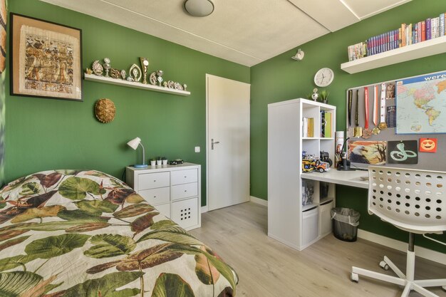 Um quarto com paredes verdes e uma cama e mesa