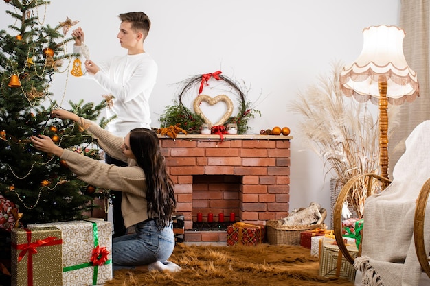 Um quarto de hóspedes decorado para o Natal por um casal apaixonado Uma quente atmosfera de Natal junto à árvore de Natal e à lareira