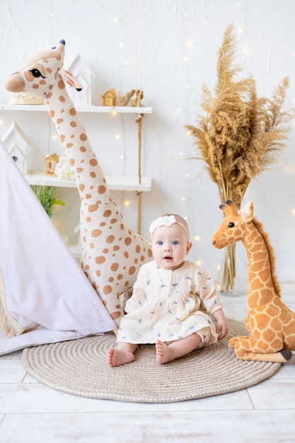 Um quarto infantil com um tentwigwam O bebê está brincando em um quarto infantil aconchegante e brilhante em casa Interior aconchegante e brilhante para um quarto infantil ou uma sala de jogos Uma garotinha com brinquedos em um piso de madeira