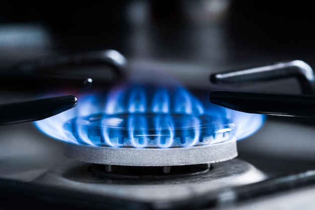 Um queimador de gás de chama azul em um fundo escuro
