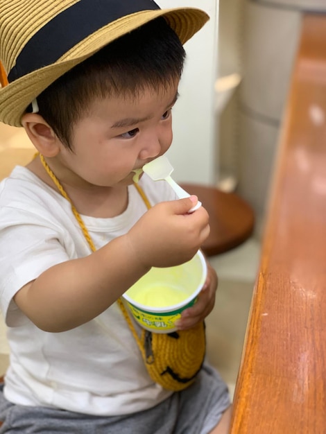 Foto um rapaz bonito a comer gelado.