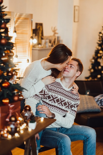 Um rapaz e uma mulher comemoram o Natal juntos em um ambiente acolhedor