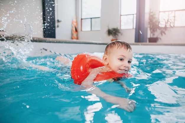Um rapaz sorridente a nadar na piscina.