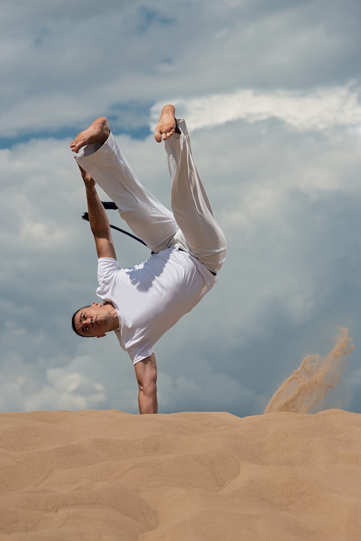 Foto um rapaz treina capoeira contra o céu. um homem realiza um truque acrobático