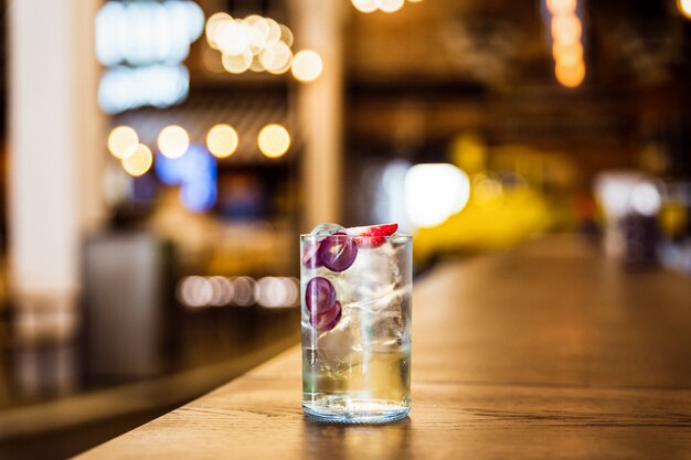 Um refrescante long drink gelado com uvas e morango no bar