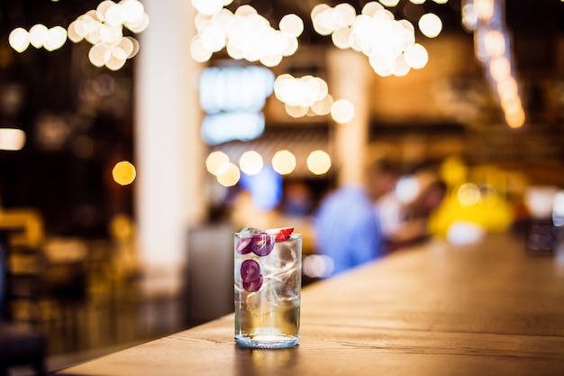 Um refrescante long drink gelado com uvas e morango no bar