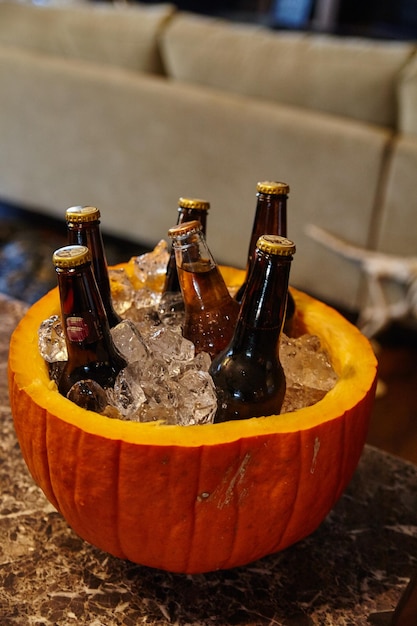 Um refrigerador de cerveja de abóbora de outono em um balcão de mármore em uma reunião interior festiva