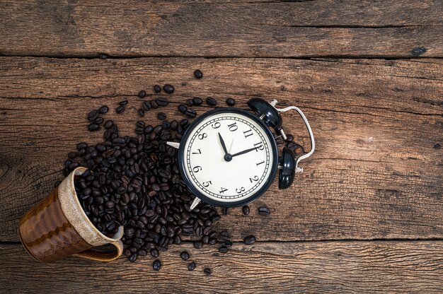 Foto um relógio e grãos de café na mesa, vista superior