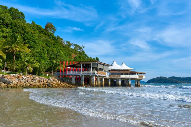 Um restaurante em frente ao mar de uma ilha tropical.