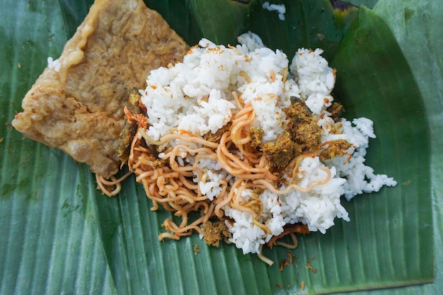 Foto um retrato da comida balinesa chamada nasi jingo na folha de bananeira