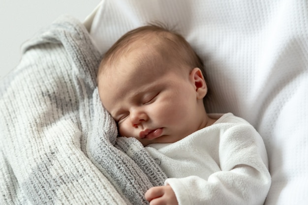 Um retrato de close-up de uma menina que dorme em um berço ou berço