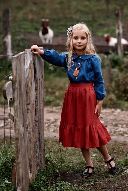 Um retrato de crianças bonitas em lindo vestido em uma fazenda