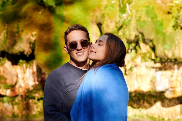 Um retrato de foco raso do adorável jovem casal hispânico em pé na natureza