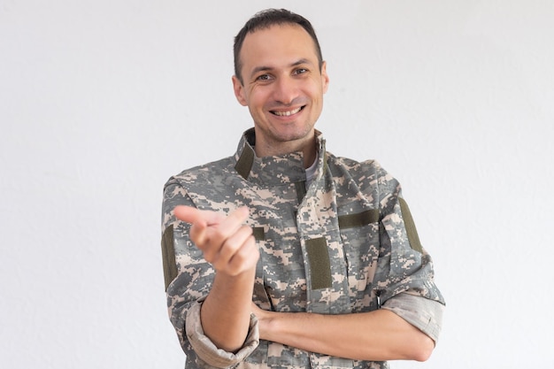 Foto um retrato de meio comprimento de soldado atraente em forma sobre branco.