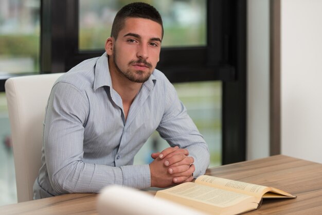 Um retrato de um homem caucasiano estudante universitário na biblioteca Profundidade de campo rasa